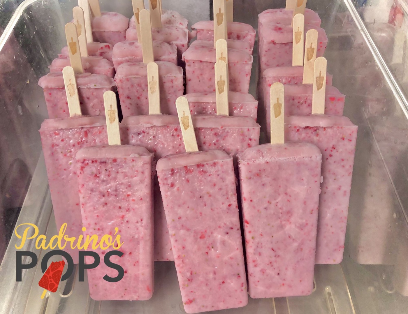 A tray of strawberry paletas with visible pieces of fruit